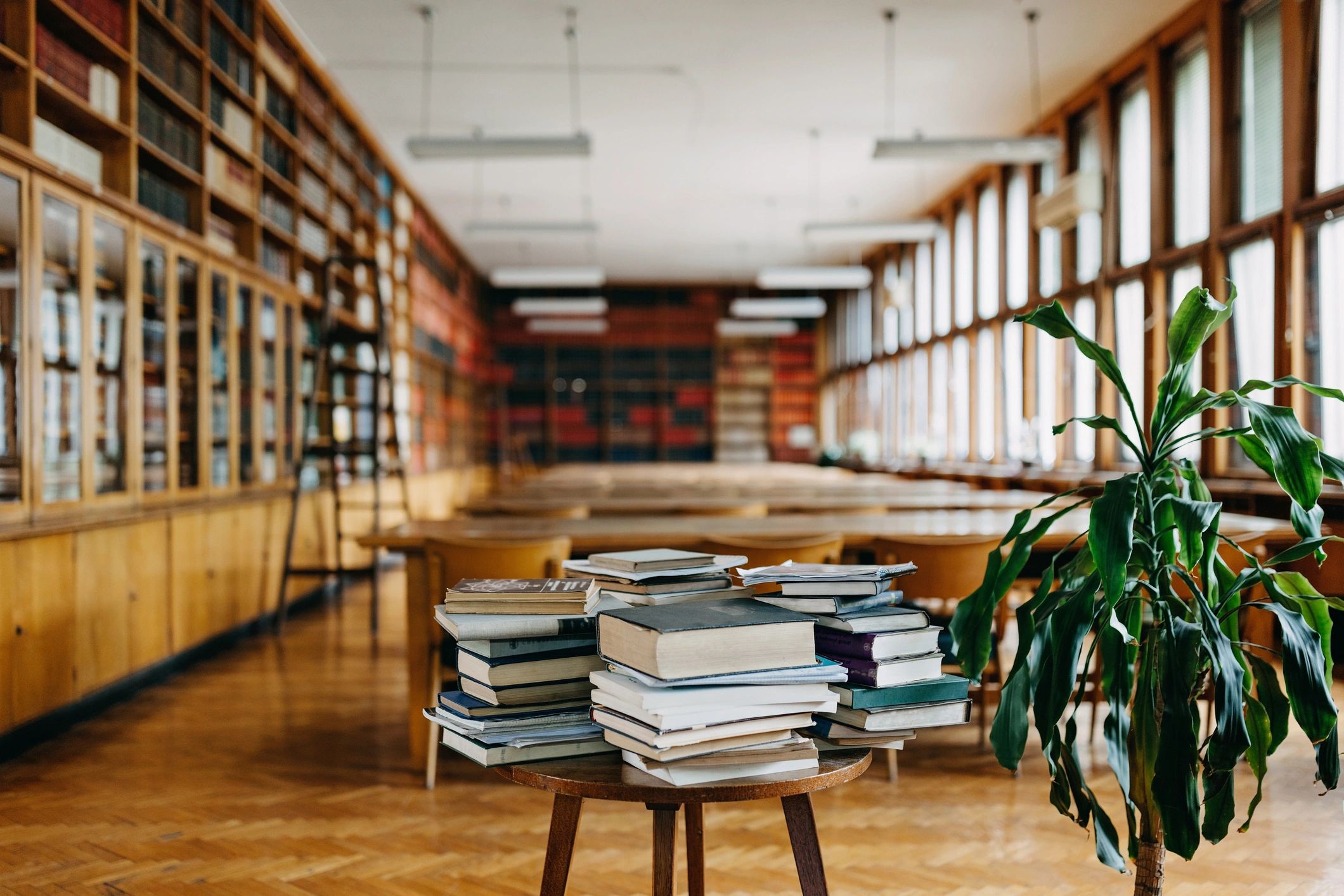 Livros empilhados em mesa de biblioteca